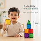 Child holding a yellow building block with text about block size and structure height, set against a neutral background.